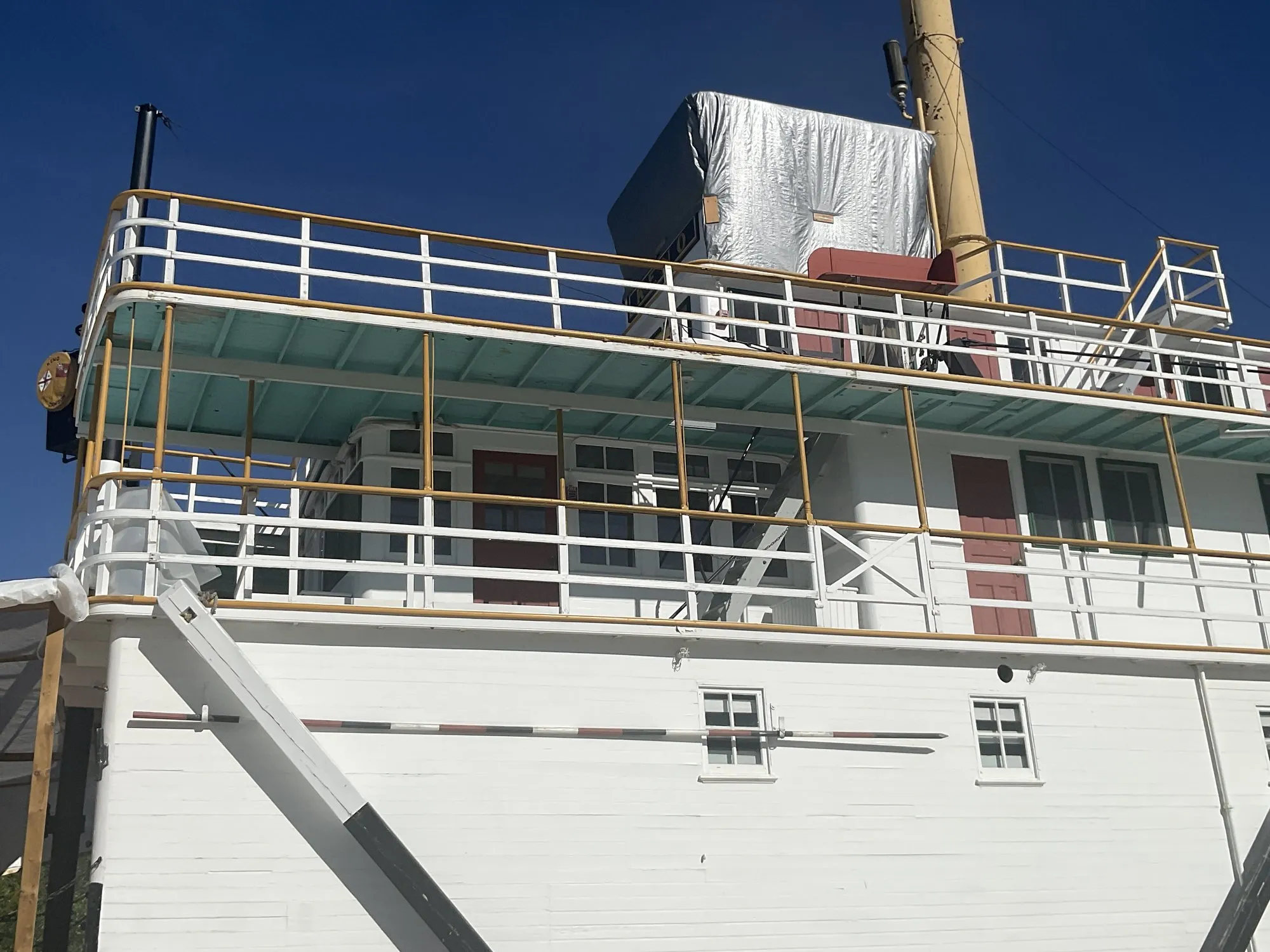 Saloon and texas decks with railings and red cabin doors, stack rising behind