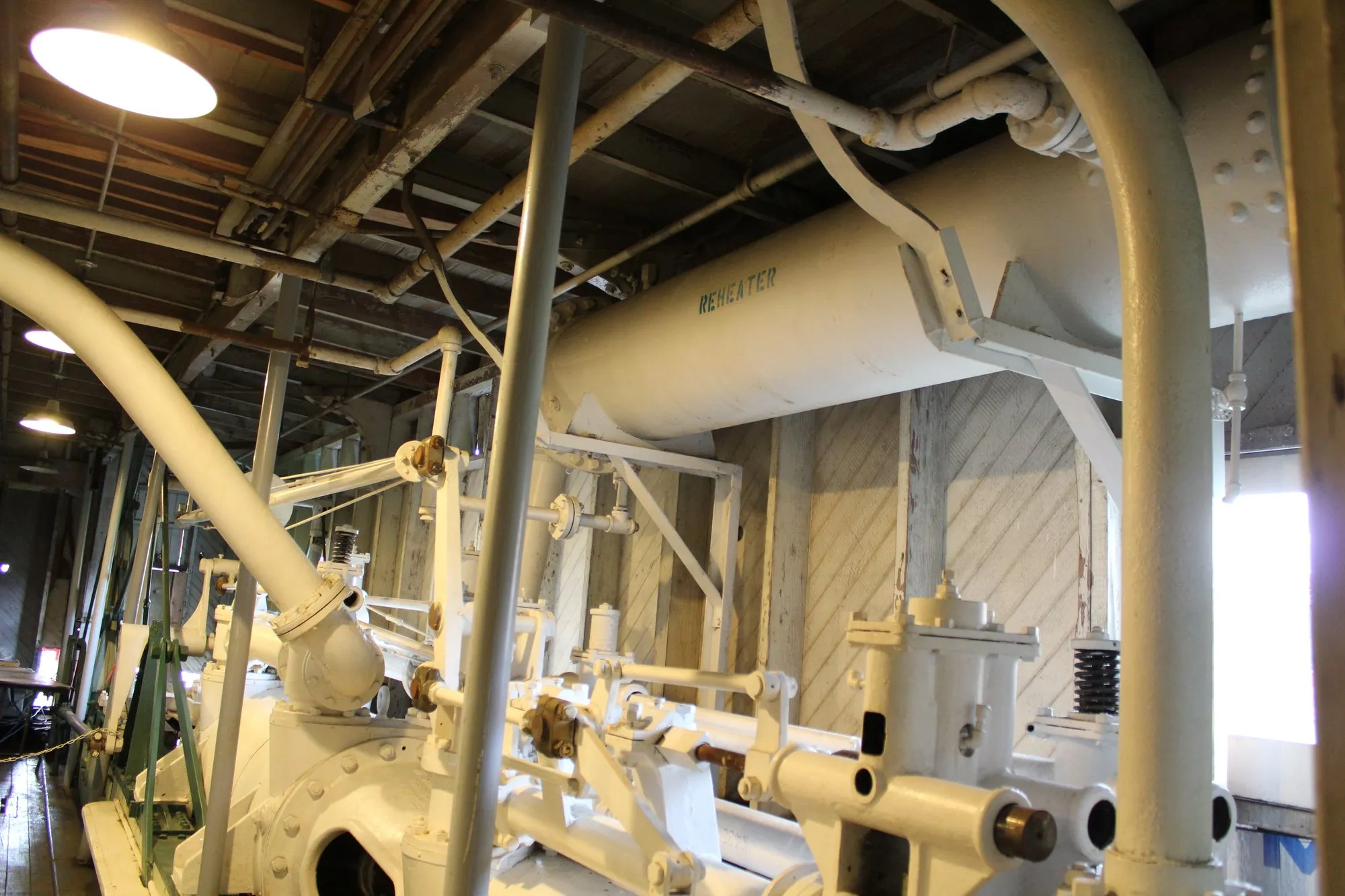 Engine valve gear in the foreground with a large horizontal vessel stencilled Reheater overhead