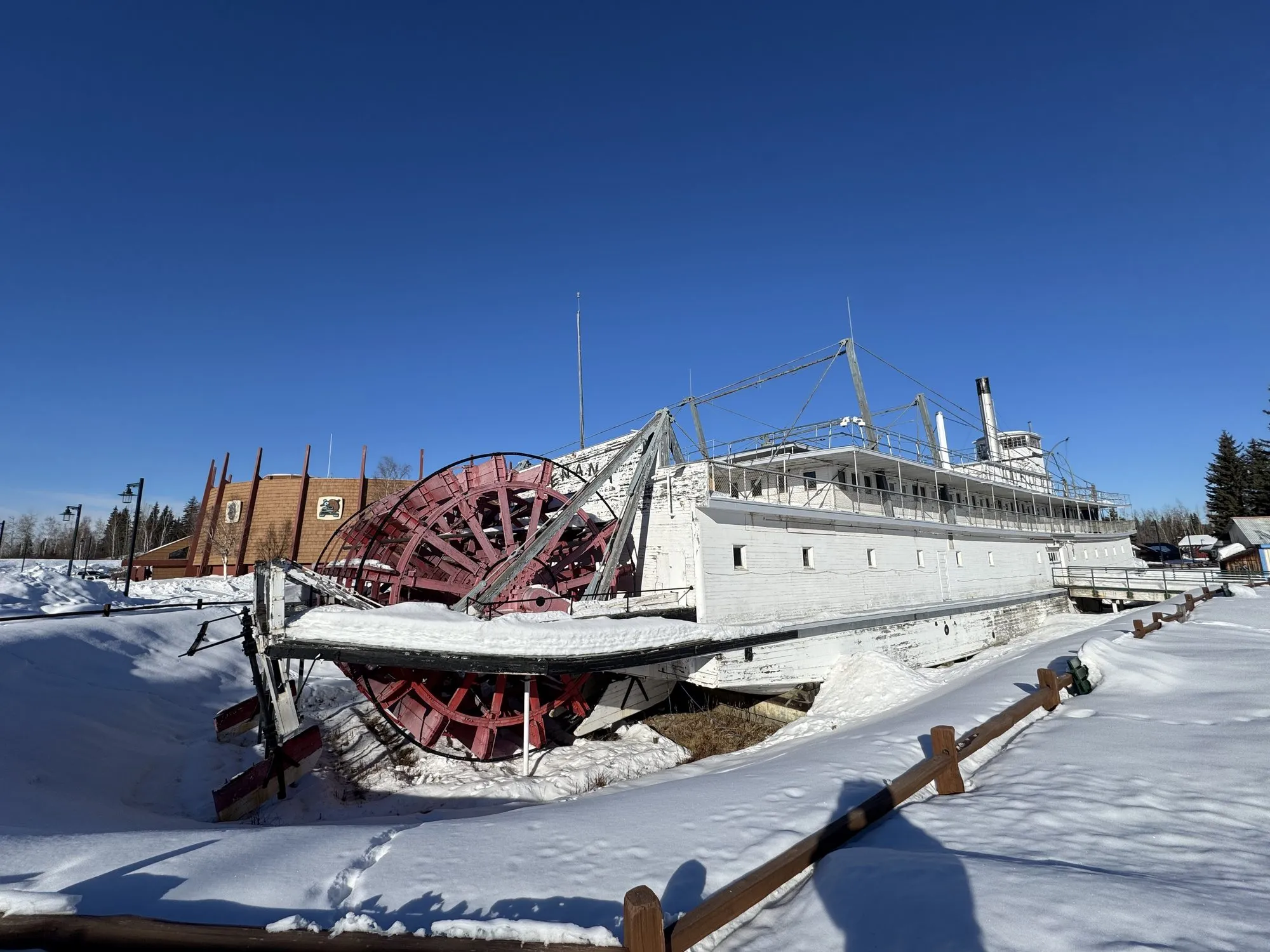 The sternwheel half buried in snow beside the hull